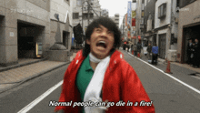 a man in a red jacket is running down a street with the words normal people can go die in a fire