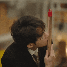 a man wearing glasses is kissing a red object