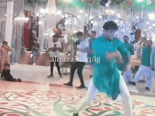 a man in a green shirt is dancing on a dance floor in front of a sign that says aliraza_iq/ig