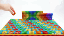 a person is playing a game with a rainbow colored board that says animatica on the bottom