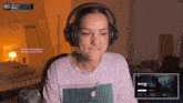 a woman wearing headphones is sitting in front of a computer monitor