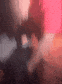 a blurry picture of a person 's face with a red light behind them