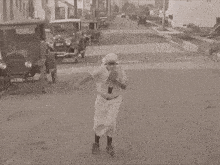 a black and white photo of a woman rollerblading down a street with a license plate that says xkc
