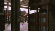a man in a red and white costume stands in a warehouse