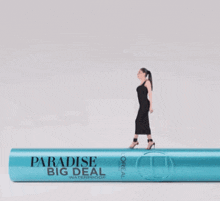a woman is standing next to a bottle of l'oreal mascara