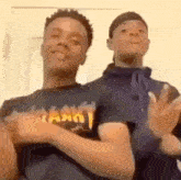 two young men are standing next to each other in a room and making funny faces .