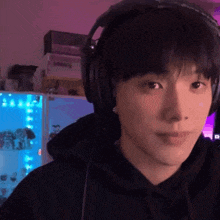 a close up of a person wearing headphones with a purple background