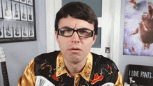 a man wearing glasses is standing in front of a poster that says i love pants