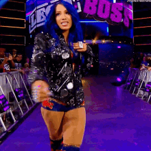 a woman with blue hair is walking down a purple aisle with the word boss in the background
