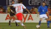 a soccer player with the number 21 on his jersey is kicking the ball