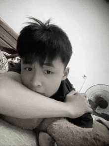 a young boy laying on a bed with his head on someone 's arm