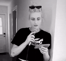 a woman singing into a microphone wearing a shirt that says " frog "