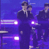 a group of men in suits and ties are dancing on a stage