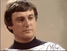 a close up of a man 's face with a turtleneck