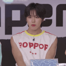 a young man wearing a white shirt that says poppop on it