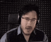 a man wearing headphones is screaming with his mouth open .