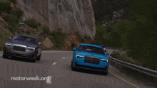 two cars are driving down a road with motorweek.org in the corner