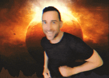 a man in a black shirt is smiling in front of a burning sun