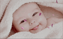 a baby is smiling with petals on his face and the words gunnaaydin written on the bottom