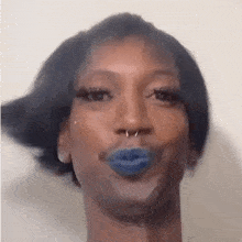a close up of a person 's face with blue lipstick and a nose ring