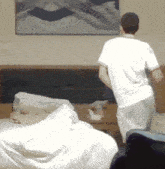 a man in a white shirt is standing in front of a painting on the wall