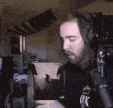 a man wearing headphones and a shirt that says ok looks at a picture