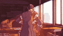 a man is standing in a classroom in front of a window looking out .