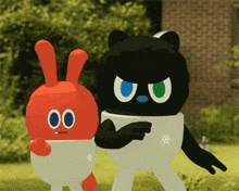 a black cat and a red bunny are standing next to each other in a field