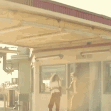 a man and a woman are walking in front of a store .