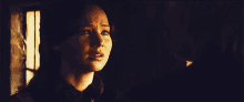 a woman is crying in a dark room with a window in the background .