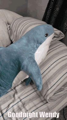 a stuffed shark on a bed with the words goodnight wendy