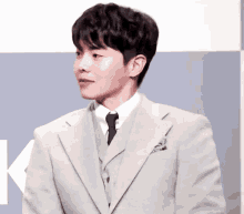 a man in a suit and tie is looking to the side