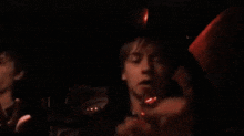 a man is sitting in the back seat of a car at night with a red light on his head .