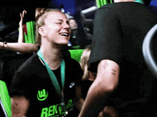 a woman with a medal around her neck is wearing a black shirt with rex on it
