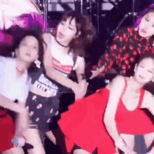 a group of women are dancing on a stage in a club .