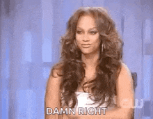 a woman with long hair is sitting in a chair and making a funny face .