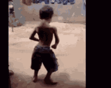 a young boy is dancing in a room with clothes hanging on a clothes line .