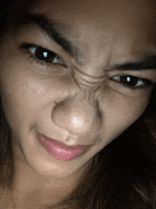 a close up of a woman 's face making a face