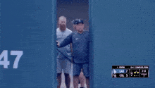 a group of baseball players are walking out of a locker room .