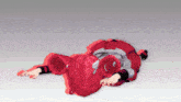 a girl with red hair is laying on the ground
