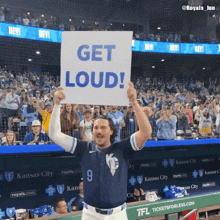 a baseball player holds a sign that says get loud