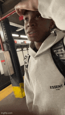 a person wearing a white hoodie that says essent
