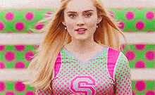 a woman wearing a pink and green cheerleading uniform with the letter s on it