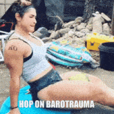 a woman with a tattoo on her arm that says ko sits on a blue cushion