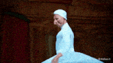 a man in a white costume is dancing in front of a red curtain with a watermark that says minimax on the bottom