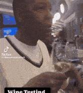 a man drinking a glass of wine with a tiktok watermark
