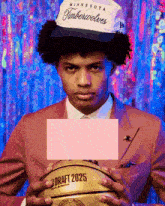 a man holding a basketball that says draft 2025