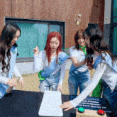 a group of girls are playing a game and one girl has a green sash that says ' eun ' on it