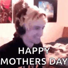 a man wearing headphones is sitting in front of a computer and saying happy mother 's day .