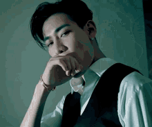 a man in a suit and tie is covering his mouth with his hand